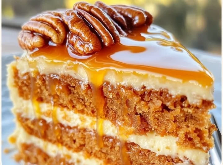 Slice of Southern Pecan Sweet Potato Cake topped with pecans and cream.