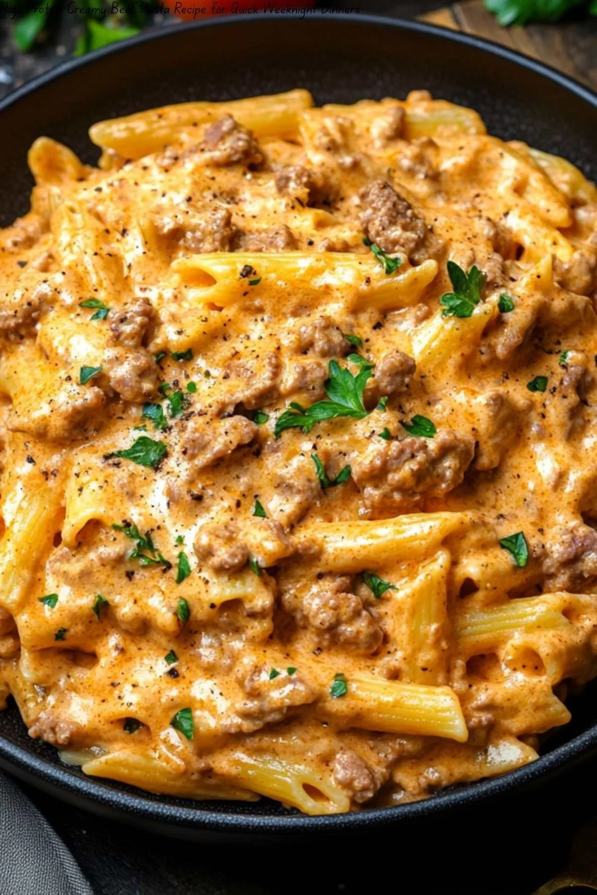 Plate of creamy beef pasta topped with parsley and grated cheese
